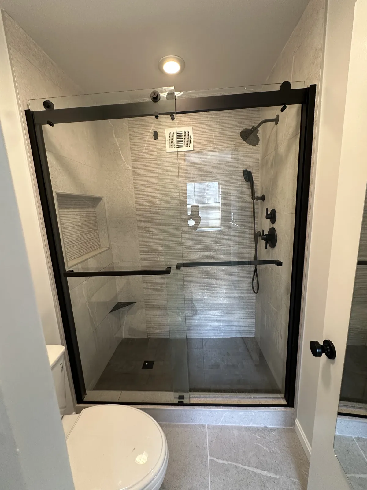 Tiled shower with sliding glass door