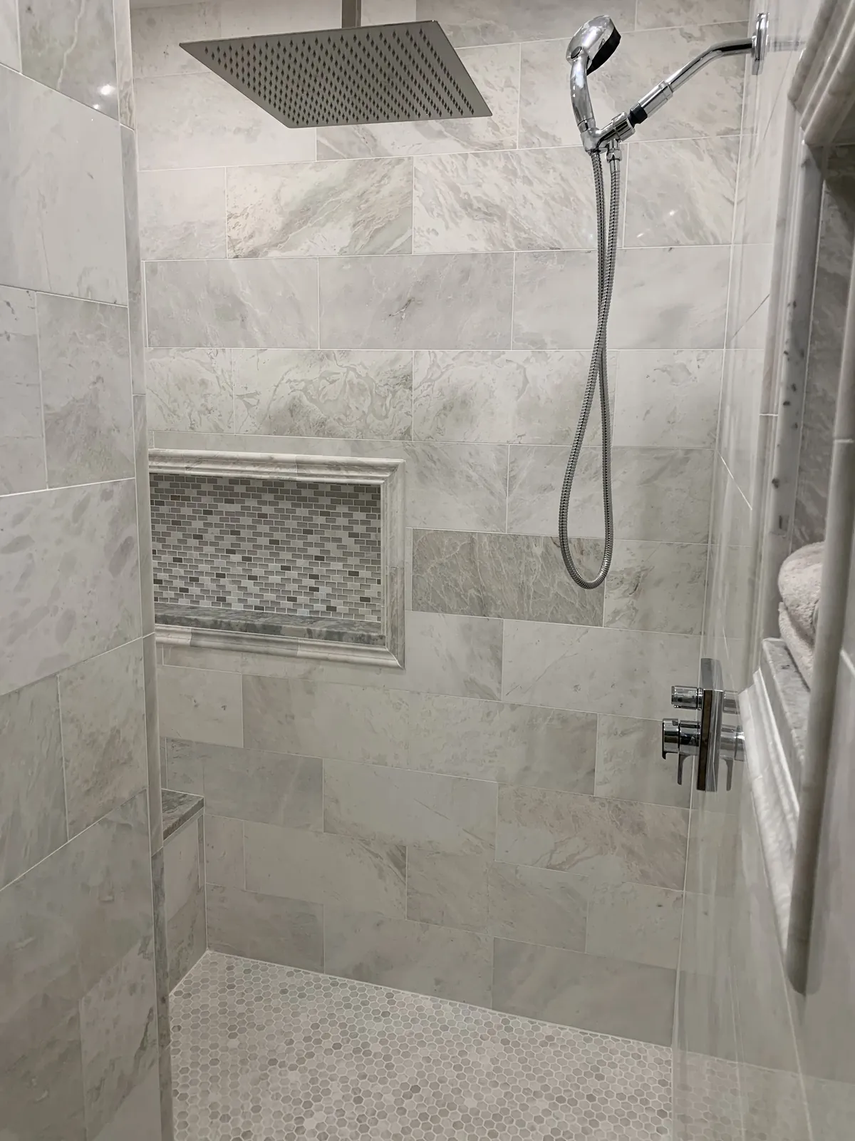 Marble shower with mosaic niche