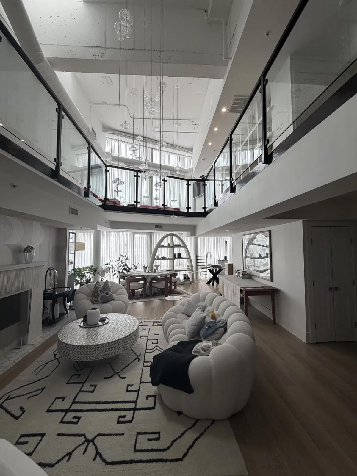 Two-story living room with glass loft railing
