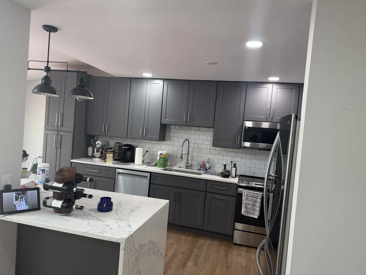 Gray shaker cabinets and waterfall quartz island